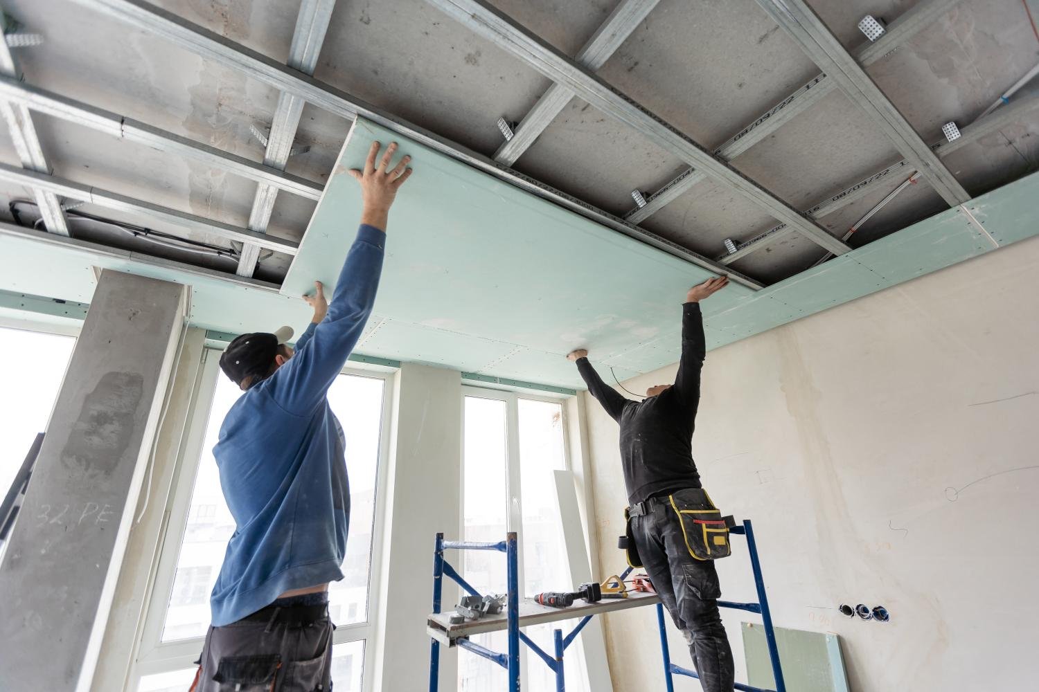 workers-fitting-panel-into-frame-of-ceiling-2026-01-07-05-32-28-utc